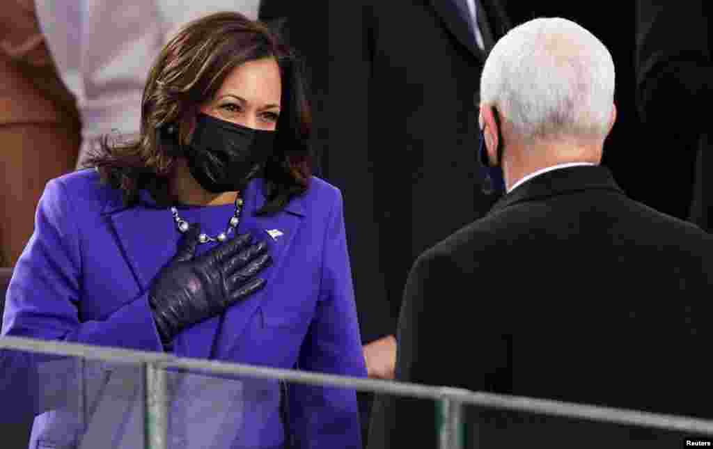 Vice President-elect Kamala Harris gestures towards U.S. Vice President Mike Pence ahead of the inauguration of Joe Biden as the 46th President of the United States .
