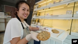 Pastry chef Elaine Lau holds a Dim Sum Cookie at the Sunday Bakeshop in Oakland, Calif., Thursday, Aug. 19, 2021. (AP Photo/Eric Risberg)