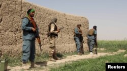 Afghan policemen keep watch during a battle with the Taliban in Nahr-e Saraj district of Helmand province, Afghanistan, May 11, 2016. 