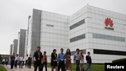 华为技术有限公司的员工走过广东省深圳市的公司办公楼（2012年4月17日）。