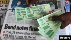 Un vendeur de rue montre les nouveaux billets dans la capitale de Harare, Zimbabwe, le 28 novembre 2016.