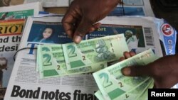 Un vendeur de rue montre les nouveaux billets dans la capitale de Harare, Zimbabwe, le 28 novembre 2016.