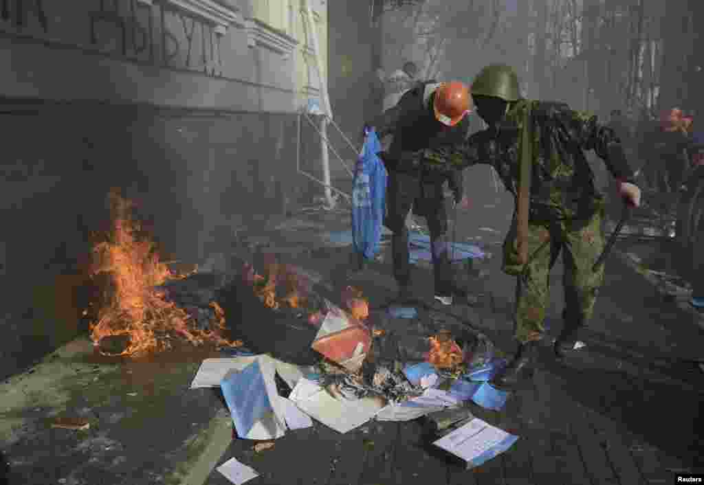 Anti-government protesters burn the Party of the Regions flags, calendars and booklets during a rally, Kyiv, Feb. 18, 2014. 