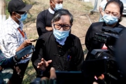 FILE - Khin Maung Zaw, center, a lawyer assigned by the National League for Democracy party to represent deposed Myanmar leader Aung San Suu Kyi, speaks to journalists outside the Zabuthiri Township Court in Naypyitaw, Myanmar, March 1, 2021.