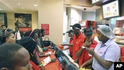 Customers wait to place their orders at a Kentucky Fried Chicken [KFC] restaurant at the Nakumat junction in Nairobi, Kenya, August 23, 2011.
