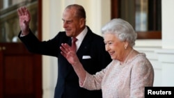 La reine Elizabeth et le Prince Philip font signe au président colombien Juan Manuel Santos et sa femme Maria Clemencia de Santos après leur visite à Buckingham Palace à Londre, le 3 novembre 2016.