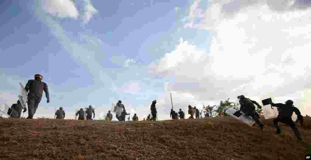 Riot police charge towards demonstrators as opposition supporters and students block a highway in the Altamira neighborhood of Caracas, April 15, 2013. 