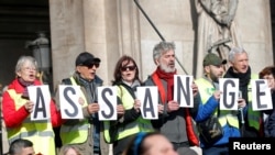 Protesters hold signs demanding freedom for Wikileaks founder Julian Assange in front of the Opera Garnier in Paris, France, Feb. 17, 2020. 