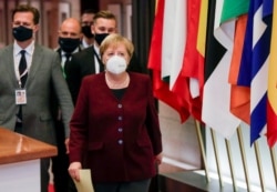 German Chancellor Angela Merkel leaves during as officials depart at the end of an EU summit in Brussels, Belgium, Oct. 16, 2020.