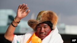 Kami Rita, 48 tahun, pemandu pendakian atau Sherpa Nepal, melambaikan tangan saat tiba di Kathmandu, Nepal, dalam arsip foto 20 Mei 2019. Rita kembali mencetak rekor dengan mencapai puncak Everest untuk ke-23 kalinya, sekaligus menumbangkan rekornya sendiri.

