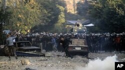 Protester runs for cover during clashes with Egyptian riot police, Cairo, Nov. 21, 2011.
