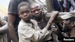Boys take a break from panning for gold at the Marco gold mine in Mukungwe locality, Congo, May 9, 2014.