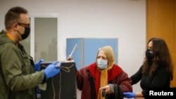 A woman wearing a protective mask casts her ballot for Portugal's presidential election, amid the coronavirus disease (COVID-19) pandemic in Lisbon, Portugal, Jan. 24, 2021. 