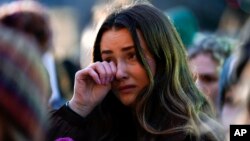 FILE - A mourner wipes a tear during a vigil honoring the students killed and injured in Monday's shootings at Michigan State University, at The Rock on the grounds of the university in East Lansing, Mich., Wednesday, Feb. 15, 2023. (AP Photo/Paul Sancya)