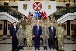 FILE - U.S. President Donald Trump, accompanied by U.S. Forces Korea Commander Gen. Vincent Brooks, center left, and Secretary of State Rex Tillerson, first row second right, poses at the Eighth Army Operational Command Center at Camp Humphreys.