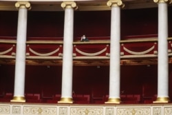FILE - A journalist wearing a protective mask attends an extraordinary session of questions to the government at the National Assembly in Paris, March 19, 2020.
