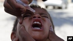 FILE - An Afghan health worker gives a polio vaccination to a child in Jalalabad, Afghanistan, June 10, 2012.