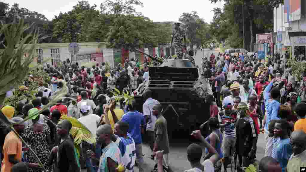 Demonstrators celebrate what they perceive to be an attempted military coup d'etat, with army soldiers riding in an armored vehicle in the capital Bujumbura, Burundi, May 13, 2015. 