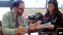 FILE - In this Wednesday, Sept. 23, 2015 photo, Dr. Rick Sacra reviews patient cases with Dr. Anna Chon at the Family Health Center in Worcester, Mass., where he advises doctors in training. 