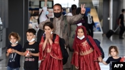 FILE - Afghan refugees arrive at Dulles International Airport on Aug. 27, 2021, in Dulles, Virginia, after being evacuated from Kabul following the Taliban takeover of Afghanistan.