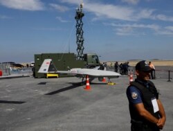 FILE PHOTO: A police officer stands next to an unmanned aerial vehicle (UAV) during Teknofest airshow at the city's new airport in Istanbul on Sept. 22, 2018.
