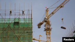 Ouvriers sur un chantier de construction dans une zone industrielle à Beijing, Chine, le 14 Avril 2016.