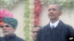 នាយក​រដ្ឋមន្រ្តី​ឥណ្ឌា​ Narendra Modi ខាង​ឆ្វេង និង​លោក​ប្រធានាធិបតី​សហរដ្ឋ​អាមេរិក​ បារ៉ាក់​ អូបាម៉ា ខាង​ស្តាំ​ មើល​ចេញ​ទៅ​ក្រៅ​ពី​ក្រោយ​កញ្ចក់​ការពារ​ទឹក​ដើម្បី​ទស្សនា​ក្បួន​ដង្ហែរ​នៅ​ក្នុង​ទីក្រុង New Delhi ប្រទេស​ឥណ្ឌា​ កាល​ពី​ថ្ងៃ​ទី​២៦​ ខែ​មករា​ ឆ្នាំ​២០១៥។