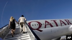 Pengunjung menaiki pesawat Boeing 777-200LR milik Qatar Airways dalam Dubai Airshow di Dubai, 14 November 2011. (Foto:Dok)