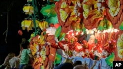 FILE - Float riders throw beads from a float with the theme "Beastly Kingdoms," in the Krewe of Orpheus parade on Napoleon Ave. during Mardi Gras celebrations in New Orleans, Feb. 24, 2020. 