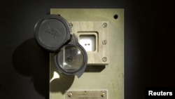 Tiga sampel batu bulan, yang menurut Sotheby satu-satunya batu bulan yang terdokumentasi dan berada dalam kepemilikan individu, yang berasal dari misi tidak berawat Soviet Luna-16 pada tahun 1970 yang kembali ke bumi dan diperlihatkan terbungkus dalam kotak berpenutup kaca dengan lensa yang dapat disetel, New York, 15 Oktober 2018 (courtesy: Sotheby via Reuters)