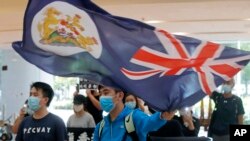 A protester waves a Hong Kong colonial flag in a shopping mall during a protest in Hong Kong, June 12, 2020. 
