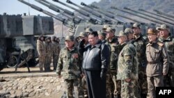 Pemimpin Korea Utara Kim Jong Un (tengah) bersama anggota Tentara Rakyat Korea (KPA) selama latihan artileri pasukan gabungan di lokasi yang dirahasiakan di Korea Utara. (Foto: via AFP)