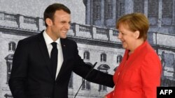 Kanselir Jerman Angela Merkel (kanan) dan Presiden Perancis Emmanuel Macron saling menyapa dengan hangat pada akhir konferensi pers bersama di Berlin, 19 April 2018.