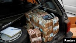 Des billets de la devise congolaise empilés à l'arrière d'une voiture dans la capitale Kinshasa de la République démocratique du Congo, 3 juillet 2012.