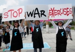 Protesters shout slogans while holding signs to oppose planned joint military exercises between South Korea and the United States near the U.S. embassy in Seoul, South Korea, Aug. 5, 2019.