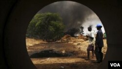 Para pekerja mengamati jaringan pipa minyak di Delta Niger yang terbakar akibat serangan para militan.