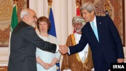 Menteri Luar Negeri AS John Kerry bersalaman dengan Menteri Luar Negeri Iran Mohammad Javad Zarif, disaksikan Menteri Luar Negeri Oman Yussef bin Alawi dan pemimpin kebijakan luar negeri Uni Eropa, Catherine Ashton (10/11), dalam pertemuan di Muscat.