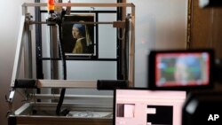 FILE - In this photo dated Monday, Feb. 26, 2018, a macro XRF scanner is used to study in minute detail the surface of Johannes Vermeer's 17th century masterpiece "Girl with a Pearl Earring", at the Mauritshuis museum in The Hague, Netherlands. (AP Photo/Mike Corder, FILE)
