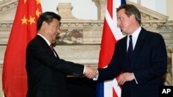FILE - British Prime Minister David Cameron, right, shakes hands with China's President Xi Jinping, at the UK-China Business Summit in Mansion House, central London, Oct. 21, 2015