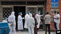 Petugas kesehatan berbicara dengan para pengunjung rumah sakit khusus pasien Covid-19 di New Delhi, India, 30 April 2020. (Foto: dok).