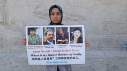FILE - Nursiman Abdureshid holds pictures of her parents and two brothers, in Istanbul in May. (Photo courtesy: Nursiman Abdureshid)
