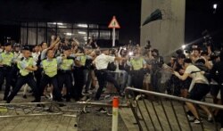 FILE - Police officers use pepper spray during a rally against a proposed extradition law at the Legislative Council in Hong Kong, June 10, 2019.
