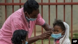 Face masks are placed on children in Antananarivo, Madagascar, Oct. 3, 2017. Authorities in Madagascar are struggling to contain an outbreak of plague that has killed at least 20 people, and the government has begun a campaign to disinfect school classroo