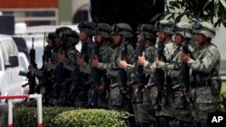 Mexican soldiers present arms as the country's Minister of Defense drives by, in Tapachula, Mexico, June 11, 2019. 