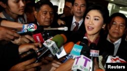 Ousted former Prime Minister Yingluck Shinawatra talks to reporters as she arrives at Parliament before the National Legislative Assembly meeting in Bangkok, Jan. 9, 2015.