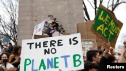 Students hold placards during a demonstration against climate change at Columbus Circle in New York, March 15, 2019. 