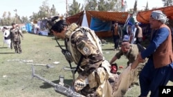 资料照:阿富汗拉什卡尔加地区发生多起爆炸后，人们抬走一名伤员。(2019年3月23日) 