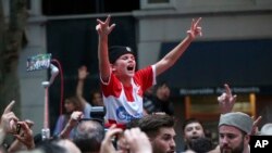 Fans of Serbian tennis star Novak Djokovic celebrate outside the Rialto building believed to be where he was located ahead of the Australian Open in Melbourne, Jan. 10, 2022. 