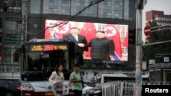 A television screen shows Chinese state media CCTV's footage of North Korean leader Kim Jong Un's meeting with Chinese President Xi Jinping in Pyongyang, at a street in Beijing, China, June 20, 2019