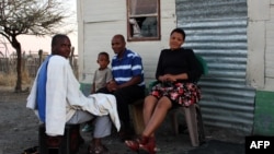 A South African miner and his family sit outside their home in Marikana, September 9, 2012.